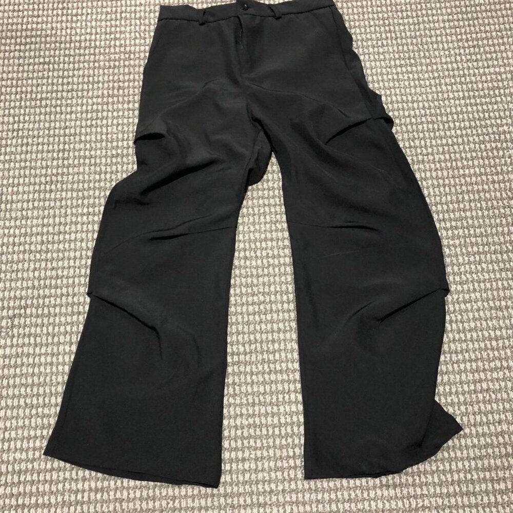 Black baggy slacks with folds. Beautiful peice, the folds make it sit right, so
